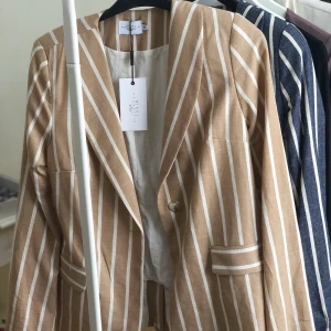 Randig kavaj - Beige, randig kavaj från NA-KD. Aldrig använd med prislapp kvar. Väldigt fin till våren