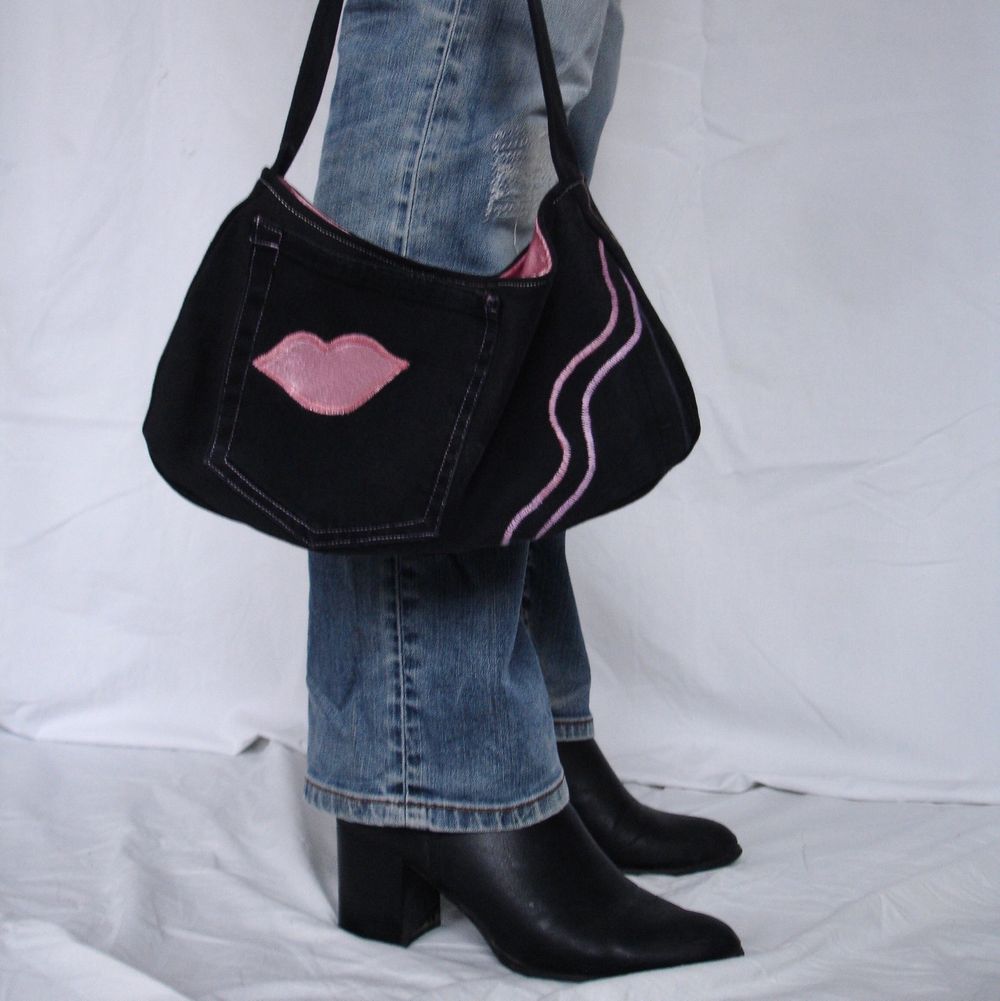 Handväska i baguettebag stuk gjord i svart jeans med en ytterficka och innerficka som har dragkedja. Insidan är i rosa som matchar applikationer. Helt handsydd, fler bilder på insta @avpermert . Väskor.