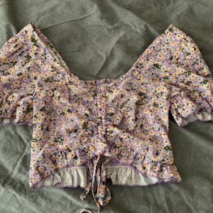 Lila topp från Shein - Lila topp med blommor från Shein. Väldigt fin på sommaren. Endast använd två gånger!✨ Köparen står för frakten. 