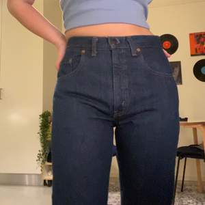 Snygga mörkblåa högmidjade levi’s jeans köpt på secondhand. Det står att storleken är W30 men sitter tight på mig som är W27. Avklippta men fortfarande väldigt långa på mig som 162cm. Väldigt bra skick!!! Frakt ingår i priset :) <3