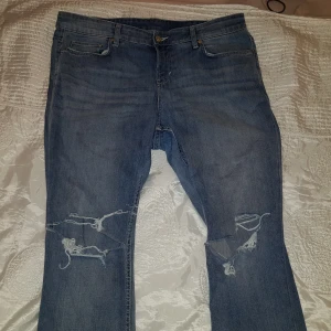 Jeans i nyskick - Jeansen har hål vid knäna och slitna detaljer. Slim regular waist.