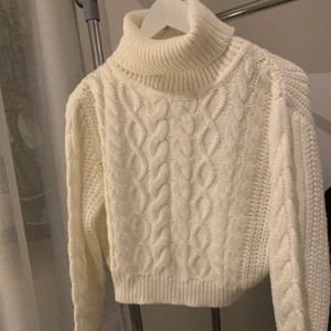 Krämvit croppad stickad polotröja  - Krämvit stickad polotröja med kabeldetaljer som är croppad. Använd endast 1gång köpt på Boohoo. Fin passform och funkar som oversized men även tightare, funkar S-L 