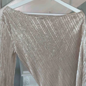  - Guldig topp med en arm, perfekt till fest 