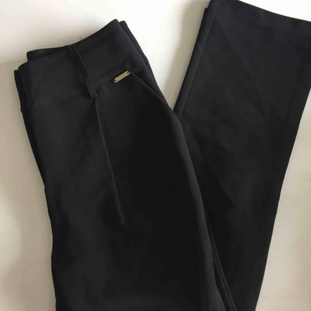 Svarta kostymbyxor från GUESS. Höga i midjan och sitter väldigt snyggt över rumpan och i midjan. Aldrig använda annat än provade. Köpta hos GUESS för 1100kr. . Jeans & Byxor.