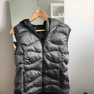  - Jättecool dunväst i silvrigt tyg, aldrig använd. Den har luva. Frakten betalar du, annars kan vi ses i Stockholm<3