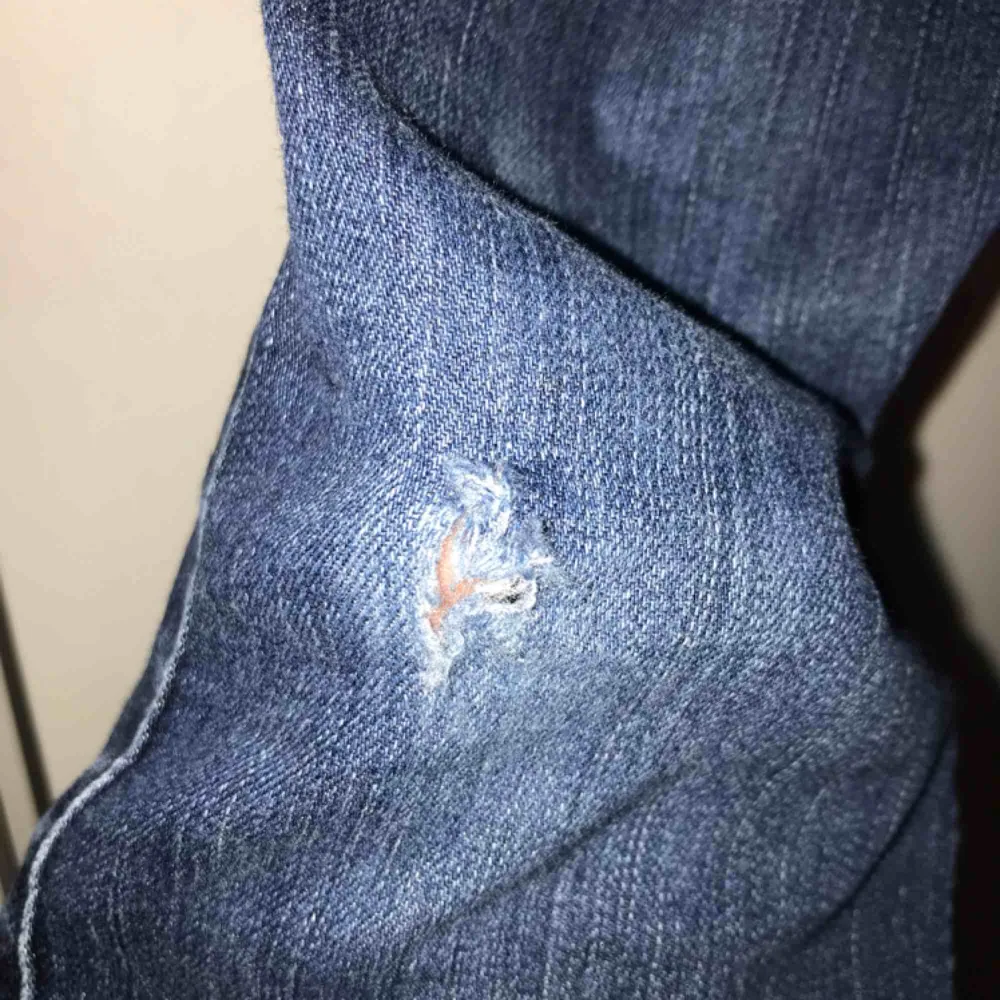 Blåa Hollister jeans. Lite slitna med ett litet hål prisas under de högra knät. . Jeans & Byxor.