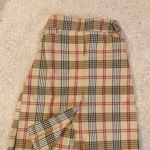  - Medium. Knä lång med slits.  Liknande burberry.  