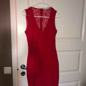  - Väldigt elegant röd klänning med spets i ryggen, kramar om kroppen, går ovanför knäna. Tjockt material  Frakt ingår