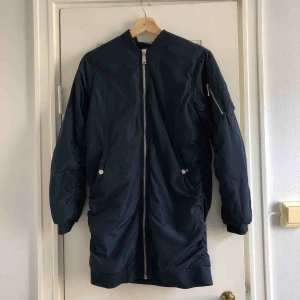  - En lång bomberjacka från Bikbok. Storlek XS/34, damstorlek. Skick: 7/10. Levereras nytvättad. Finnes på Södermalm, Stockholm. Kan postas men då står Du för frakten, (79kr). Mvh Marija & Nugget