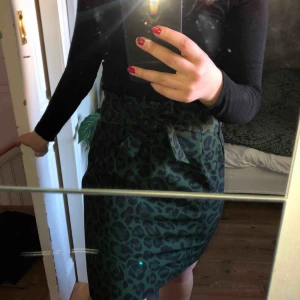  - Kjol i fint grönt leopardmönster, ALDRIG ANVÄND!!! Fraktkostnad tillkommer.