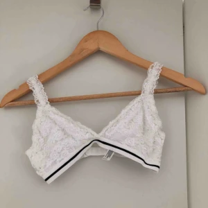  - En vit spets topp som bara har använts ett par gånger. Den har ett spänne i ryggen och det går att justera längden på axelbanden. 