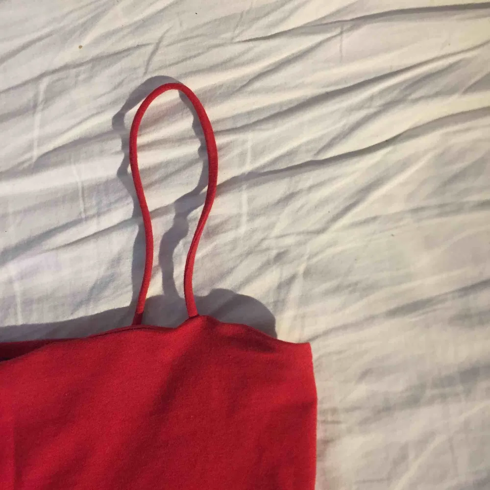 Ett rött linne med spagettistraps från gina, linnet är lite kort så det är nästan en magtröja, köparen står för frakten. Toppar.