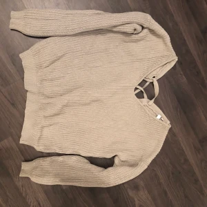 Stickad tröja - Stickad beige tröja från Nelly med korsad rygg
