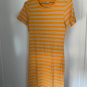 Gul, randig klänning - Gul, randig klänning från Cubus. Passformen är tight och den slutar en liten bit ovanför knäna på mig som är 1,75 lång! Kommer ej till användning och är sparsamt använd, säljer för 75 kr exkl. frakt som tillkommer!