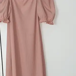 Rib square neck puff sleeve dress storlek 40 köpt från boohoo som är helt oanvänd och i nytt skick. Klänningen är i babyrosa och har små puffar vid axlarna och är superfin festklänning och sommarklänning. Klänningen passar även m och s och är ganska lång till knäna. Den är köpt för 250 och säljer minst för 150.