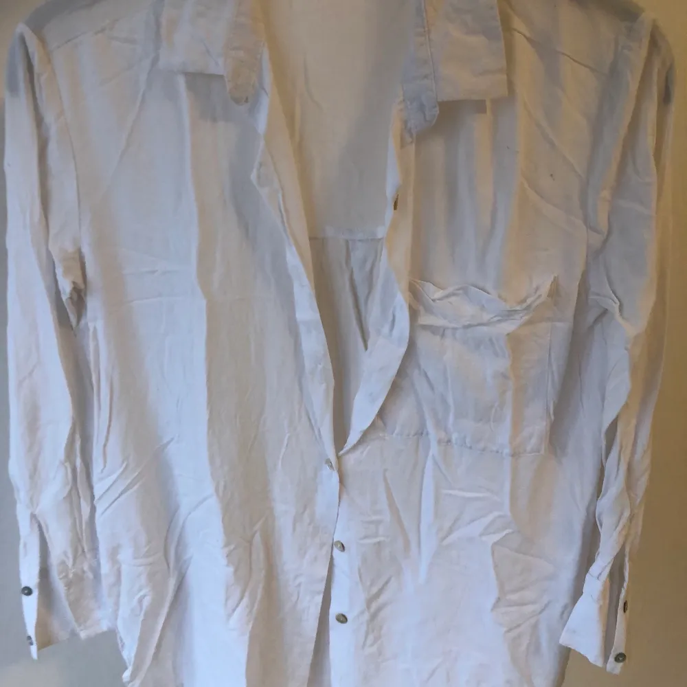 En vit skjorta/blus med lite lösare fit som är superfin och skön att ha på sommaren! Behöver endast strykas så blir det superbra. Sparsamt använd och därför i bra skick! Strl XS. Blusar.