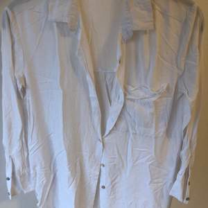 En vit skjorta/blus med lite lösare fit som är superfin och skön att ha på sommaren! Behöver endast strykas så blir det superbra. Sparsamt använd och därför i bra skick! Strl XS