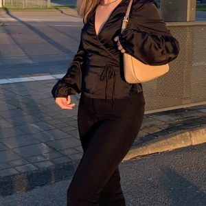 Svart satinblus omlott - Superfin omlottblus i svart satintyg med puffärmar den bikbok! Köpt i våras i storlek XS men bara använd ett par gånger, inga defekt och i fint skick. Köpt för 400, säljer för 250 gratis frakt🥰 skriv för fler bilder