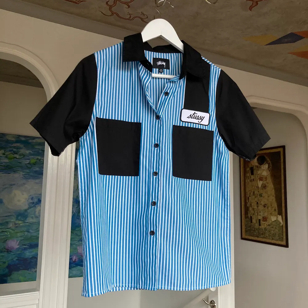 Skitsnygg kortärmad skjorta från Stüssy, använd endast 1 eller 2 gånger. Blåvita ränder och snygga svarta detaljer✌🏻 nypris: 800kr Köparen står för frakt!. Skjortor.