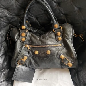 Balenciaga väska - Intressekoll! Så snygg svart Balenciaga väska med guldiga nitar. Använd men väldigt fint skick! Dustbag ingår! Skriv till mig vid frågor💕
