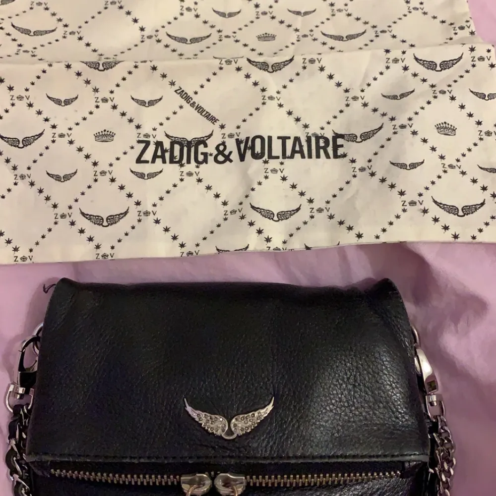 En svart Zadig Voltaire väska som har två olika band. Väskan är i helt okej skick men den har blivit lite sliten på på vissa ställen. Väskan är köpt för ca 2000. Väskan kostar 1100 kr!. Väskor.