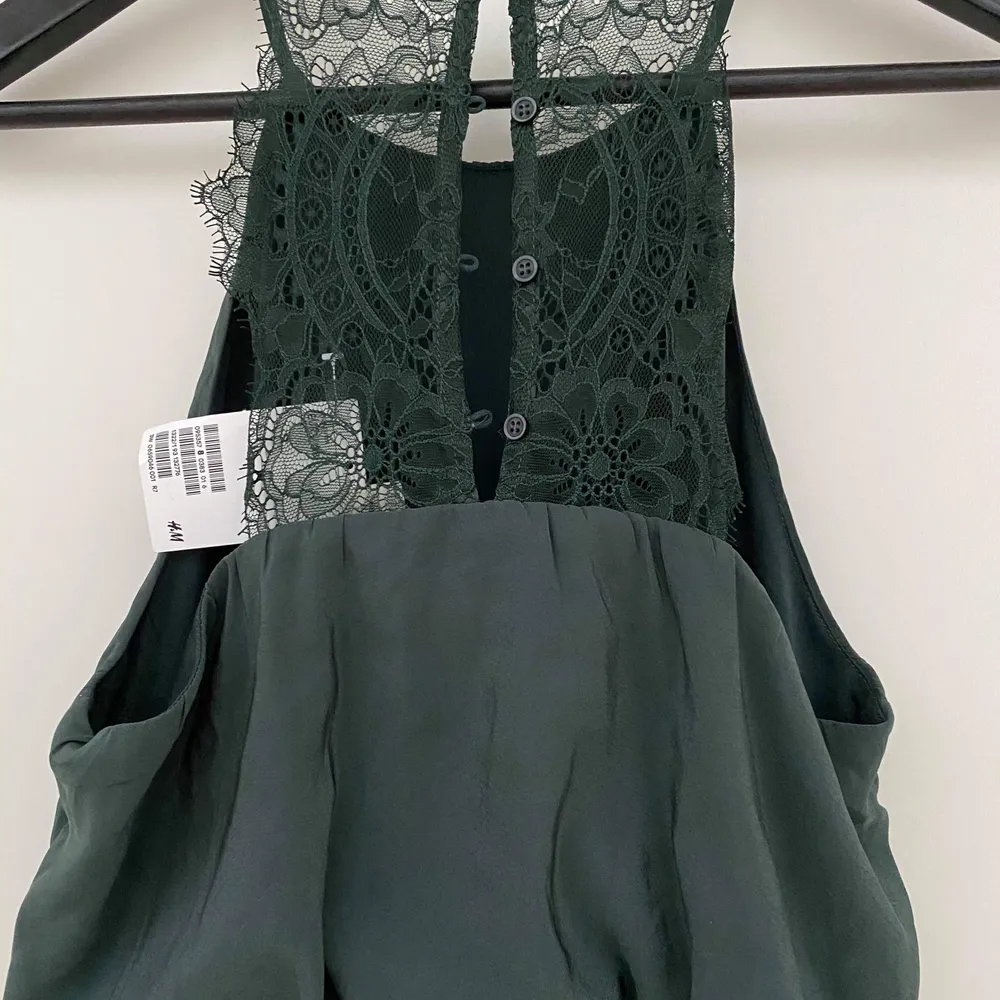 Grön klänning från HM med fina detaljer i ryggen. Lappen kvar, aldrig använd.. Klänningar.