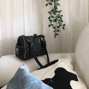  - Liten trendig väska att ha i armvecket, rymmer mycket. Litet fack med dragkedja på insidan och små öppna fack på utsidan. Ett Mönstrat, läderliknande material med två svarta handtag.