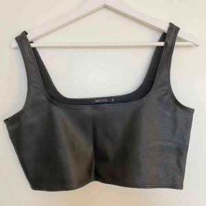  - Croppat linne i läderimitation från Nelly. Supertrendigt och stretchigt material. Toppen är använd 1 gång! Köparen står för frakt💖