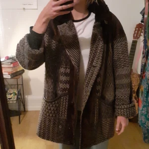 Brun Höstjacka  - Sicksackmönstrad höstjacka. 80% ull, 15% polyester , 5% a. Fasern. Jag är 178 cm, räcker precis över rumpan på mig. 