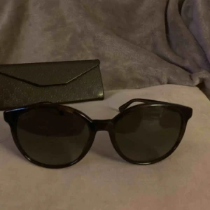 Äkta Gucci   - Snygga Gucci solglasögon. Använda med små repor på glaset. Äkthetsbevis finns samt Gucci fodral mm ingår.