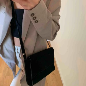  - Svart cross body väska med gulddetaljer ursprungligen från Mango. Väskan väl använd men i bra skick. 