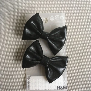  - Två hårspännen i ett skinnliknande material. Ca 6x4 cm 