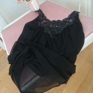  - Svart halterneck topp med paljetter med chiffongliknande genomskinligt tyg i två lager. Storlek 34.