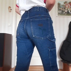  - Jätte fina jeans med blommor på och ur fickorna! Det står storlek 170 men passar bra som 36-38. Högmidjade och "snickar byxe" fickor på sidorna!