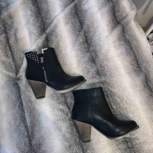  - Svarta högklackade skor med guldetaljer 