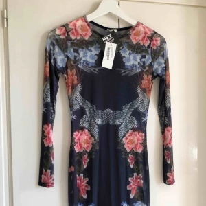  - Oanvänd transparent klänning med mönster från Nelly. Köparen står för frakt!