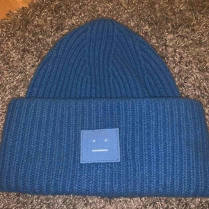  - Acne mössa i 100% nyskick i en fin klar mellanblå färg. Köpt för ca 8 månader sedan på NK i Stockholm och säljer för att jag råkar ha dubbla. Älskar färgen och passformen MÅNGA INTRESSERADE, FÖRSTA BUDET ÖVER 800 FÅR DEN!!!!