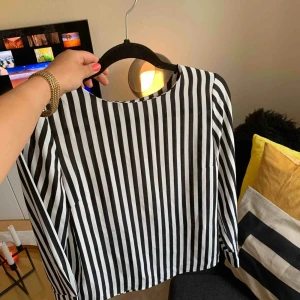  - En tröja med svarta och vita ränder. Sparsamt använd! 