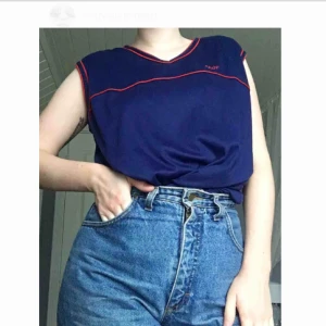  - Ett mörkblått linne med breda axelband i storlek EU38. 