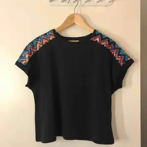 Svart T-shirt med paljett detaljer på axlarna från Zara.  Frakten är inkluderad i priset🖤💙❤️ 