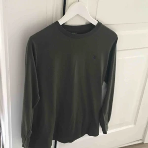  - POLO Ralph Lauren långärmad tshirt i olivgrönt. Obs. Junior-large. Djur-rökfritt hem. Porto tillkommer. 