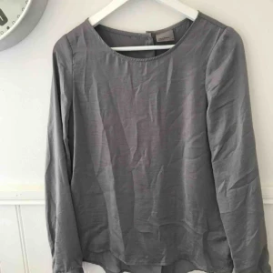  - Snygg grå blus med knappar i ryggen. Storlek S. Frakt tillkommer