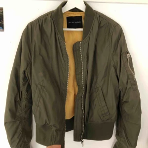  - Mörkgrön bomberjacka med gult innertyg