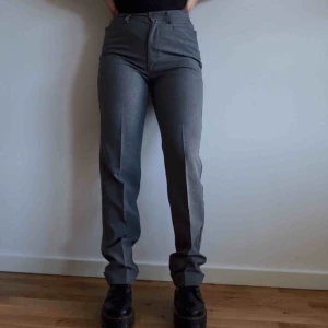  - Supersnygga gråa kostymbyxor från United Colors of Benetton. Personen på bilden är 167 cm lång och har vanligtvis storlek S/M i byxor, men byxorna går att vika ner ett steg och hade då passat någon längre än 167! Byxorna passar som en damstorlek M.