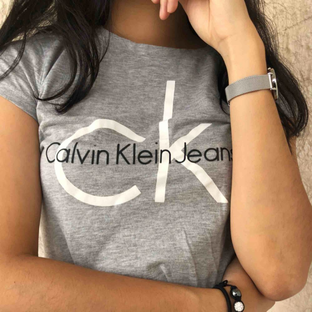 Ljusgrå t-shirt från Calvin Klein köpt i deras butik i Miami för ca ett år sen🖤 Enkel och stilren, passar bra för att piffa upp vardagsoutfiten!⚡️ Använd ett par gånger men fortfarande väldigt gott skick samt kvalité💫 Eventuell frakt står köparen för🖤. T-shirts.