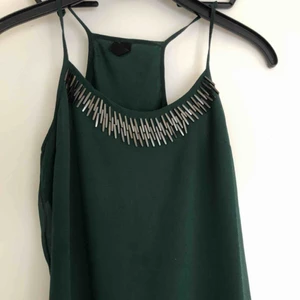  - Mörkgrönt linne med pärl-detaljer.