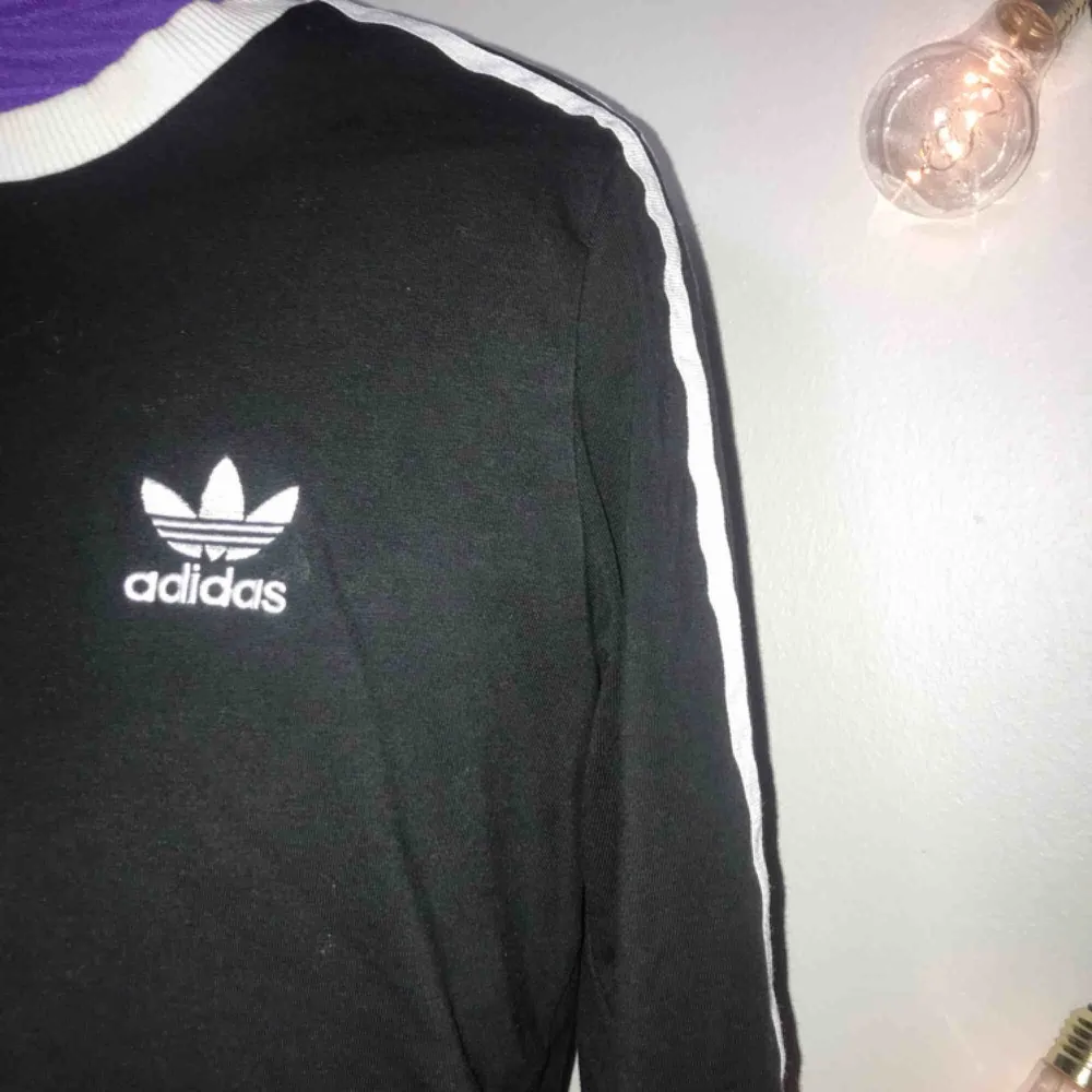 En svart/vit långärmad Adidas tröja. Nästan helt oanvänd, säljs pågrund av ingen användning. Inget fel på tröjan, jätte fin!köptes på Zalando för 489kr Nypris: ca 400kr . Tröjor & Koftor.
