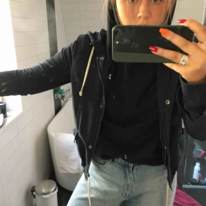  - Regnjacka i mockaliknande mörkblått material. Väldigt sparsamt använd