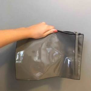  - Grå lackväska köpt på affären Judith på Hornsgatan i Stockholm. Har inte fått användning för denna så den är precis som ny. Orginalpris: 299kr