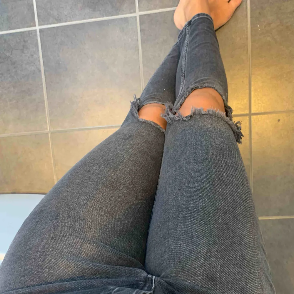 Sköna och tajta jeans med hål på knäna. Gråa och högmidjade från hm. Står storlek 27 men skulle säga s-m. Frakt tillkommer. Jeans & Byxor.
